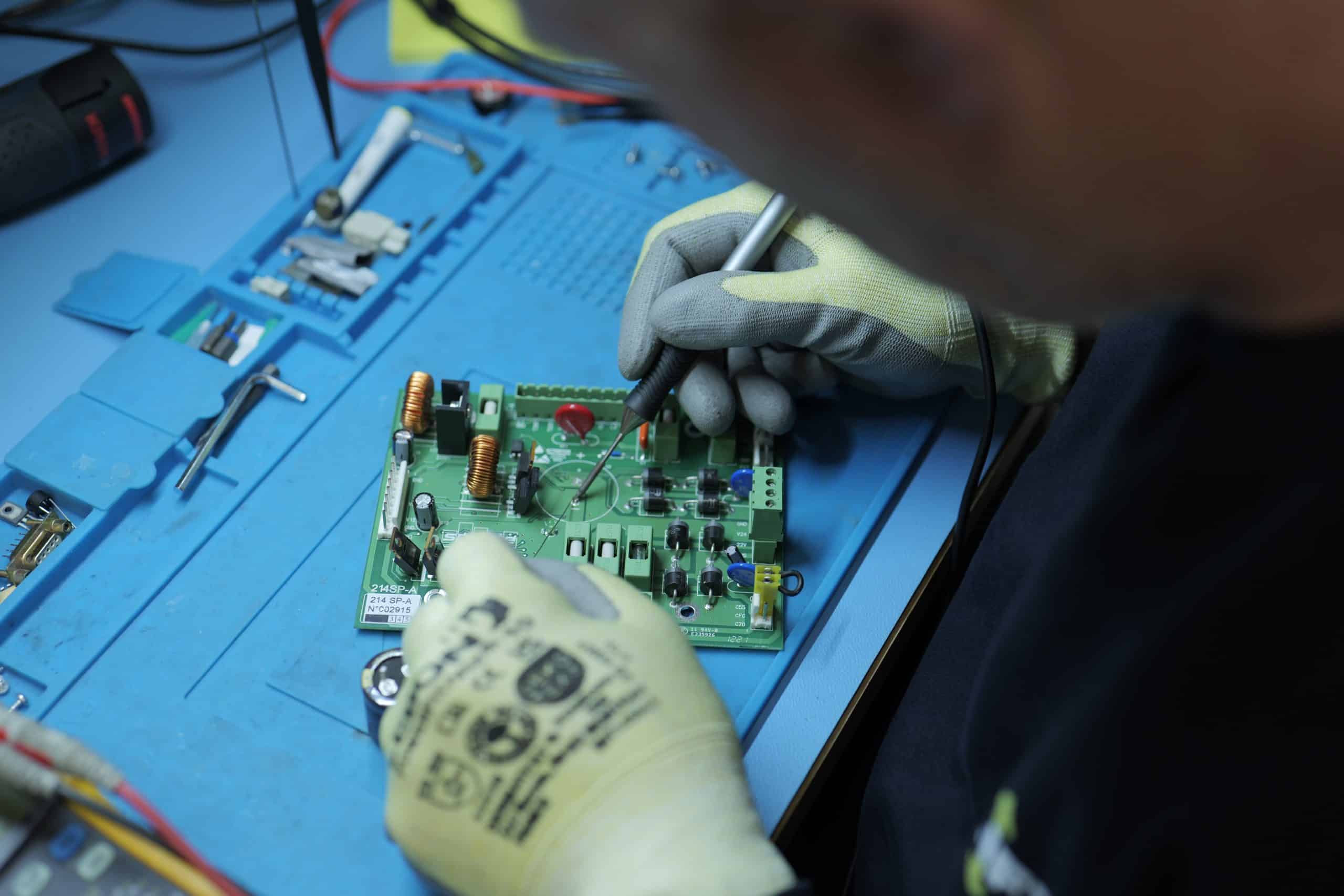 Réparateur Liftman travaillant sur une carte électronique