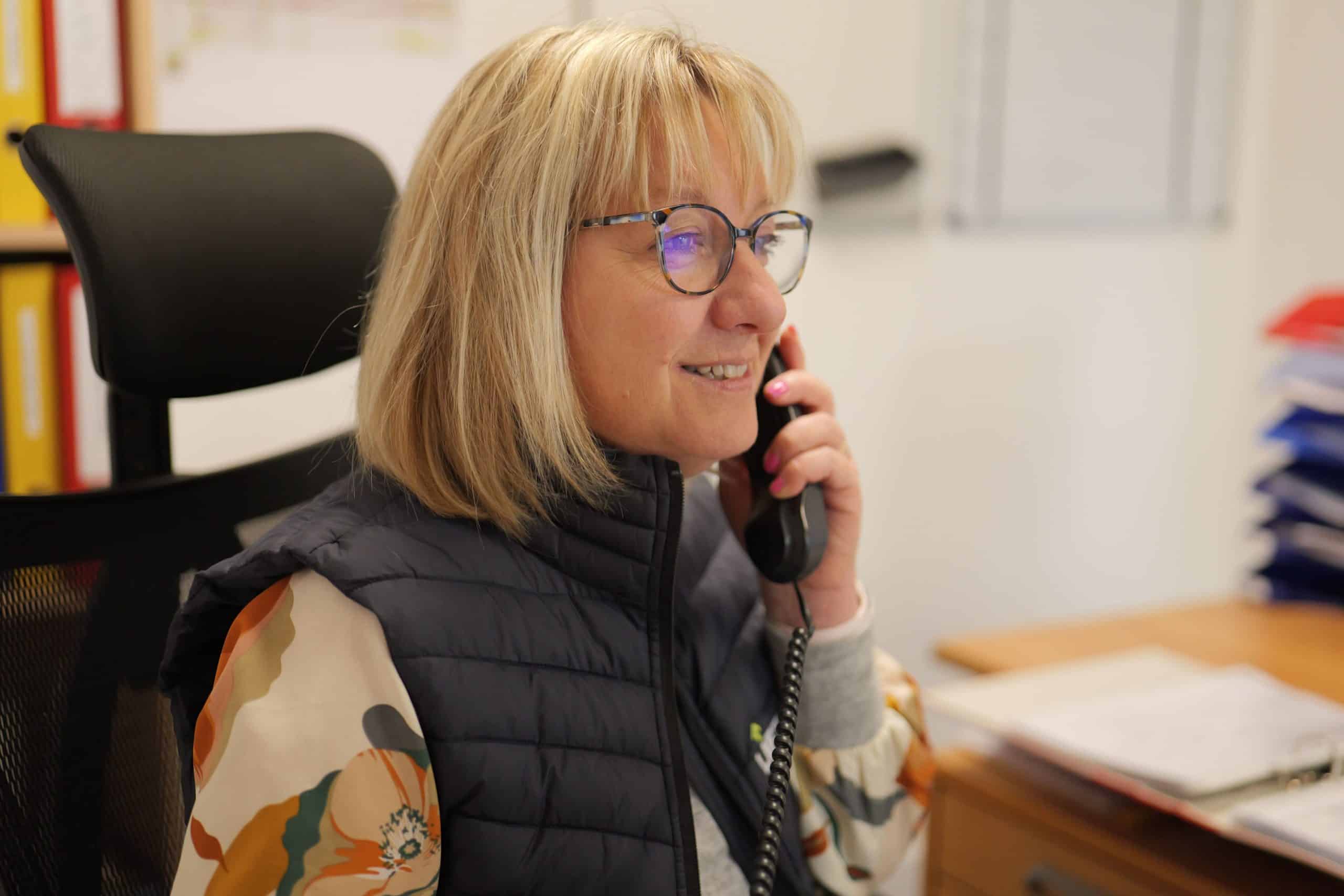 Secrétaire Liftman assise à son bureau répondant au téléphone