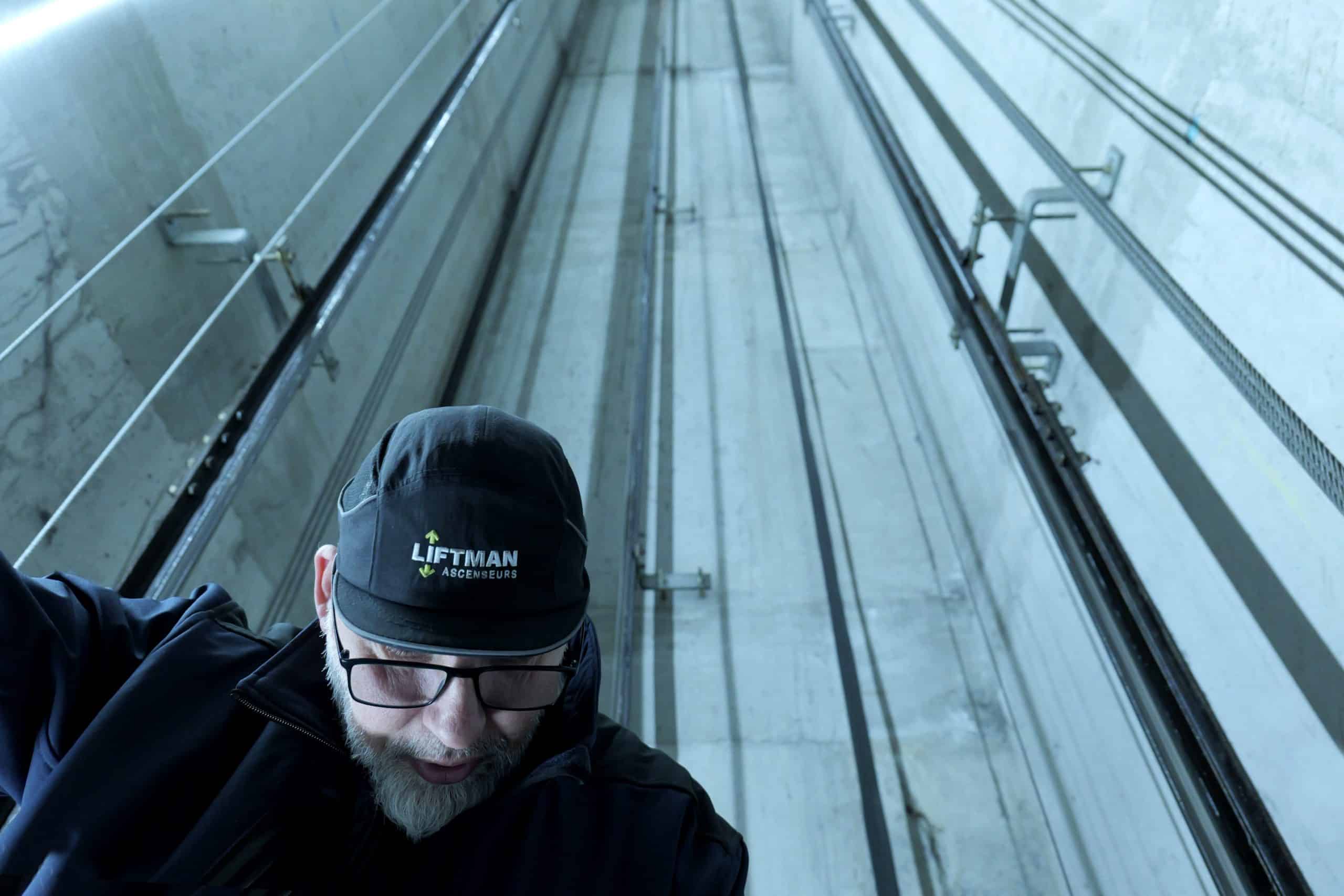 Technicien en intervention au dessus de la cabine d'ascenseur